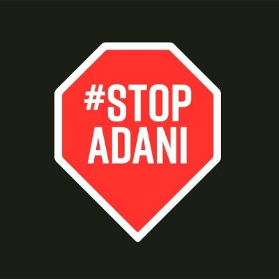The red sign says #stop Adani with black background.